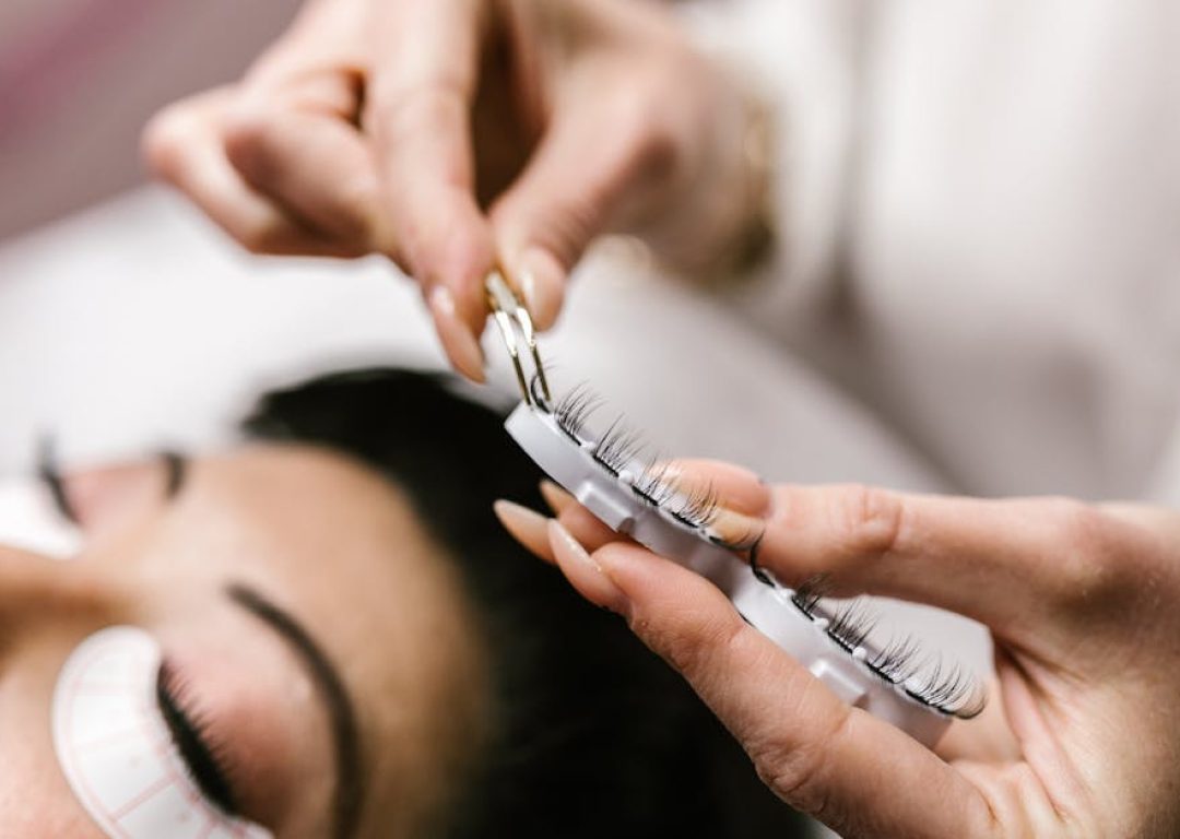 Detailed view of eyelash extension procedure in salon setting.